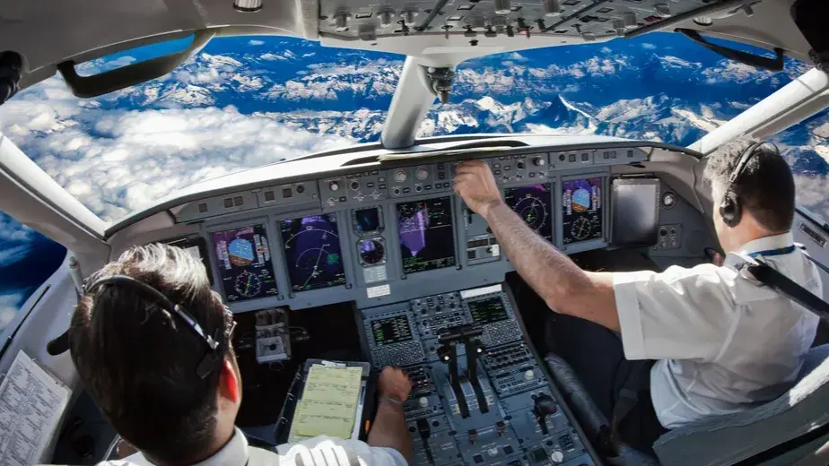 Pilots in the cockpit at high altitude relying on electronic naviagtion and monitor systems